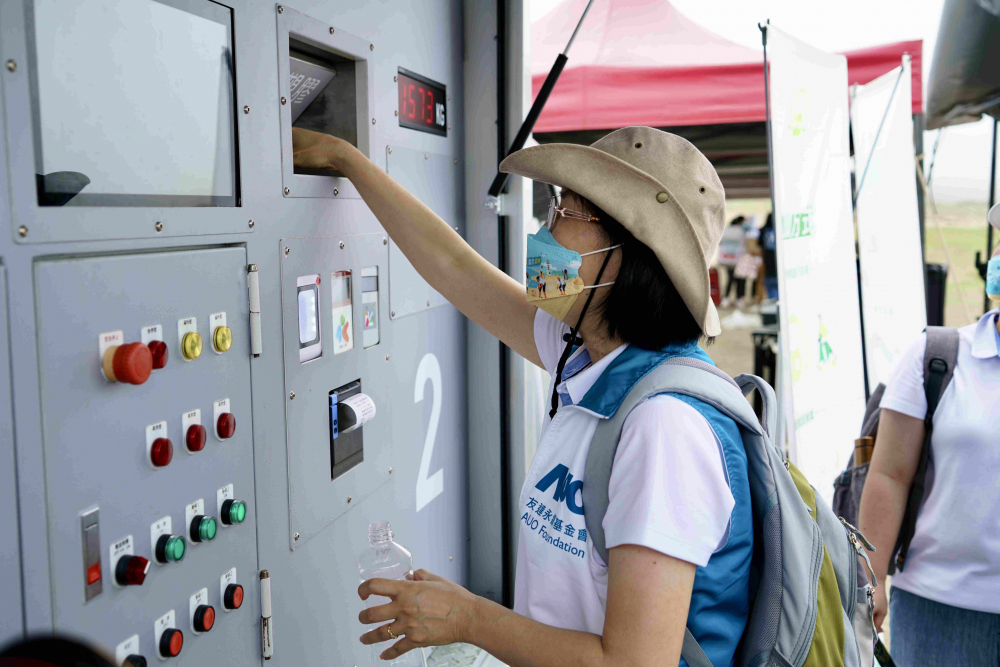 志工們將拾起的寶特瓶投入「好歸塑專車」，讓廢棄塑料空瓶可以直接粉碎、縮小體積，未來將可再製成購物袋、寶特衣、悠遊卡等生活用品